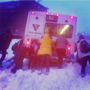 Delle persone spingono un bus per farlo partire in mezzo alla neve - CC BY elgranj.com