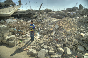 Foto che ritrae un bambino in mezzo alle macerie di Gaza