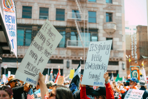 l'immagine mostra alcuni cartelloni durante la parata del no king day a Los Angeles