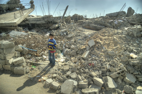Foto che ritrae un bambino in mezzo alle macerie di Gaza