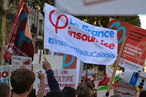 Manifestazione di piazza con striscione di France Insoumise