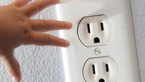 Un bambino mette le dita nella presa