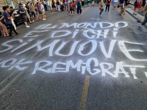 Il mondo è di chi si muove: scritta sull'asfalto al corteo fuck remigration