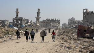 Persone camminano tra le macerie a Gaza