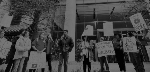 Lavoratori e lavoratrici dell'IA fanno un picchetto e mostrano cartelli