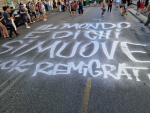 Il mondo è di chi si muove: scritta sull'asfalto al corteo fuck remigration