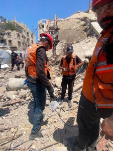 Protezione civile palestinese che  recupera i corpi  dalle macerie