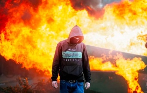 studente in una piazza albanese in fiamme