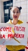 come è triste la prudenza, recita un cartello tenuto da un'attrice 